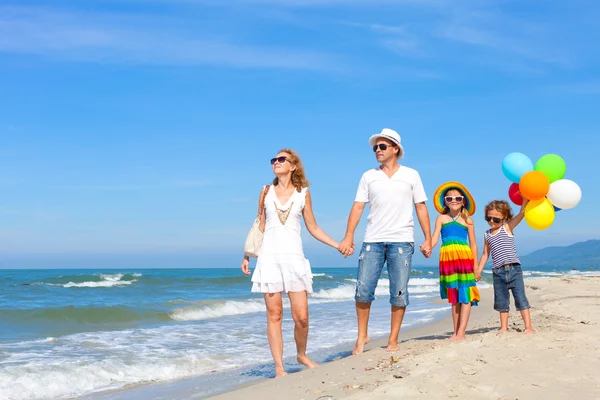 Familie fericită jucându-se cu baloane pe plajă în timpul zilei — Fotografie, imagine de stoc