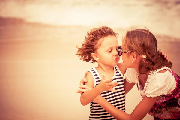 Hermana y hermano jugando en la playa durante el día . — Foto de Stock