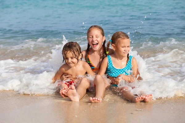 Trzy szczęśliwe dzieci bawiące się na plaży — Zdjęcie stockowe