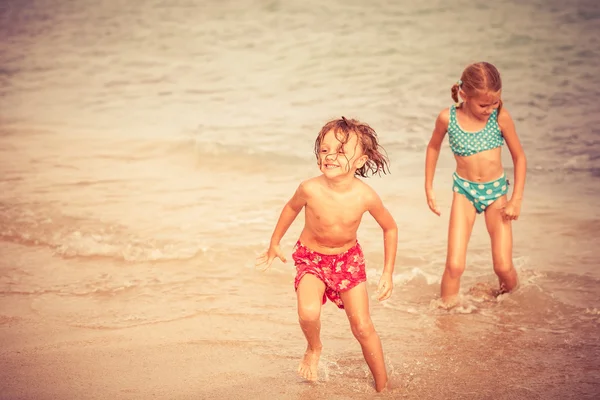 Dos niños felices jugando en la playa — Foto de Stock