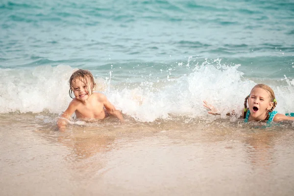 Dwa szczęśliwe dzieci bawiące się na plaży — Zdjęcie stockowe