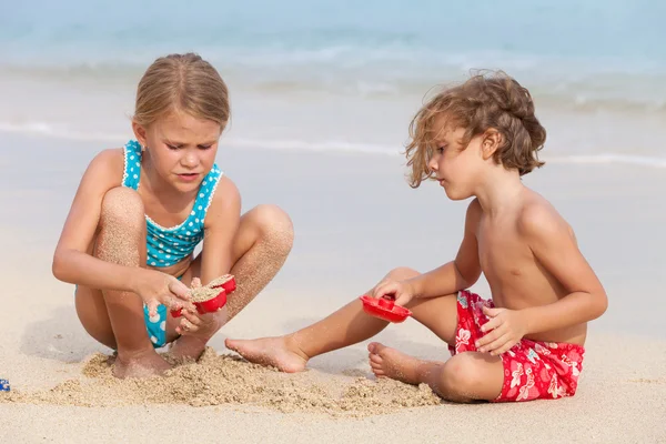 Zwei glückliche Kinder spielen am Strand — Stockfoto