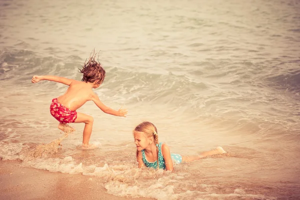Dvě šťastné děti si hrají na pláži — Stock fotografie