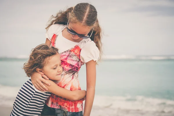 Schwester und Bruder spielen tagsüber am Strand. — Stockfoto