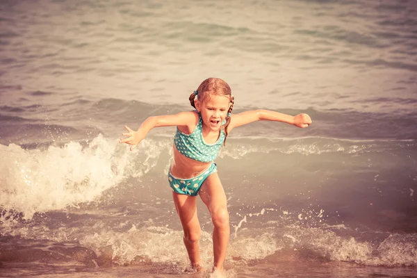 Glückliches kleines Mädchen steht am Strand — Stockfoto