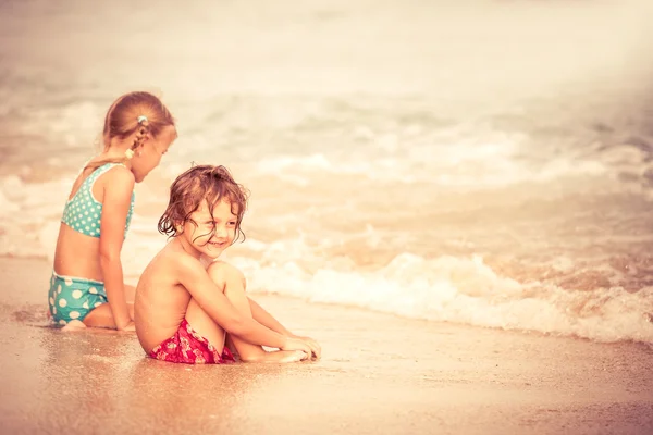 Dwa szczęśliwe dzieci bawiące się na plaży — Zdjęcie stockowe