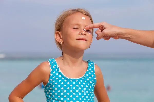 Glückliches kleines Mädchen steht am Strand — Stockfoto