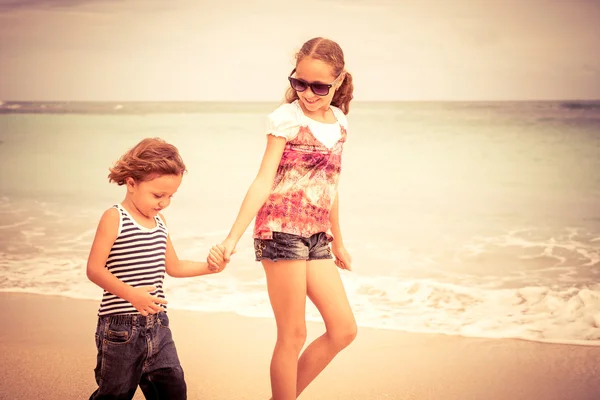 Siostra i brat gra na plaży w czasie dnia. — Zdjęcie stockowe