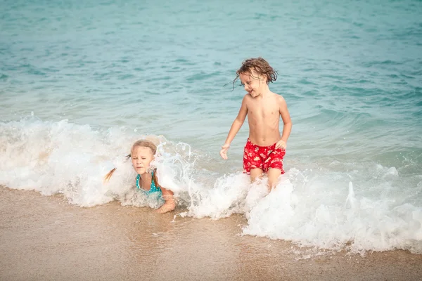 Dos niños felices jugando en la playa —  Fotos de Stock
