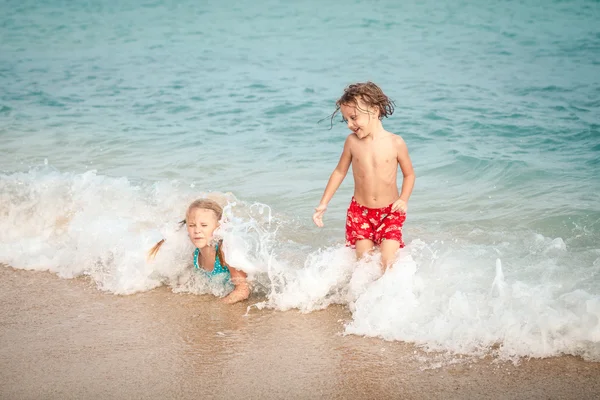 Dwa szczęśliwe dzieci bawiące się na plaży — Zdjęcie stockowe