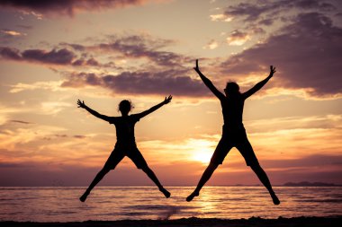 Anne ve kızı sahilde günbatımı anda oynamak