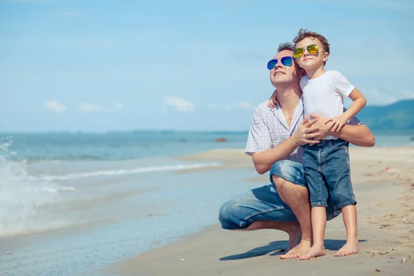 Vader en zoon spelen op het strand op het moment van de dag. — Stockfoto