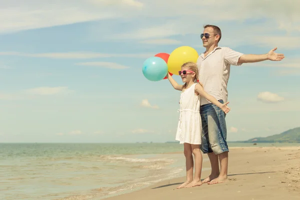 Far och dotter med ballonger spelar på stranden på da — Stockfoto