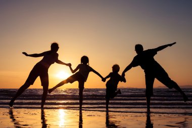 mutlu aile silüeti sunse plajda oynayan