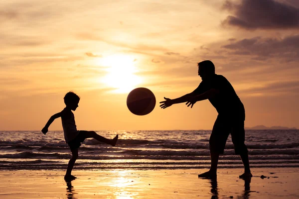 父と息子の夕日時のビーチでのプレー. — ストック写真