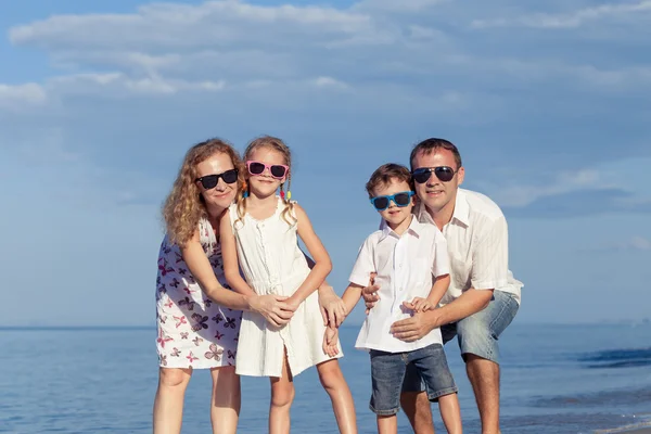 Felice famiglia a piedi sulla spiaggia durante il giorno . — Foto Stock