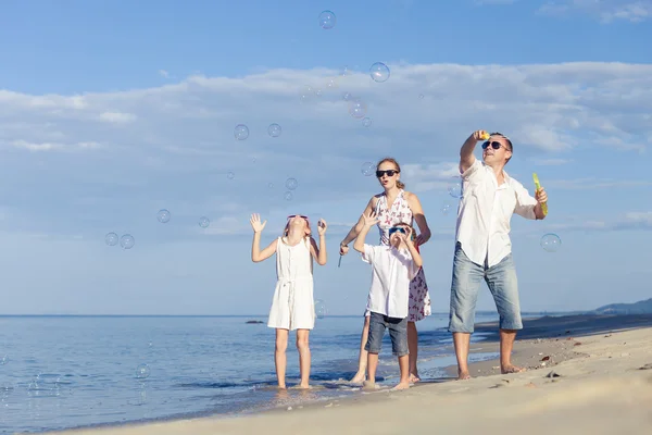 Happy family walking on the beach at the day time.