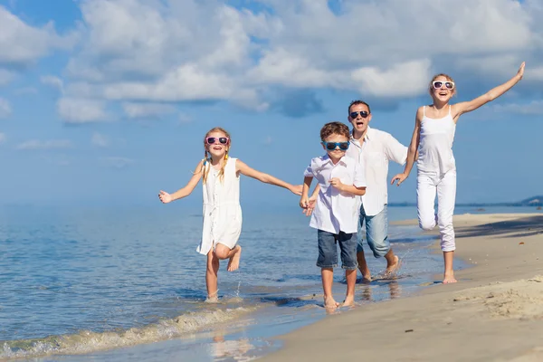 Far och barn som leker på stranden på dagarna. — Stockfoto