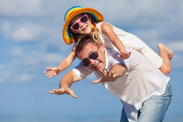 Padre e hija jugando en la playa durante el día . — Foto de Stock