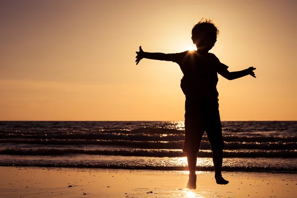 Glad liten pojke körs på stranden — Stockfoto