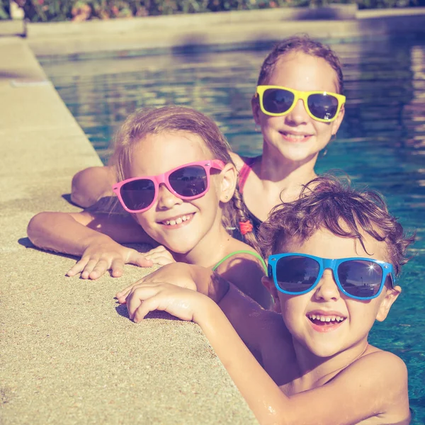 Ευτυχής παιδιά που παίζουν στην πισίνα κατά τη διάρκεια της ημέρας — Φωτογραφία Αρχείου