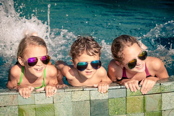 De gelukkige kinderen spelen op het zwembad op het moment van de dag — Stockfoto