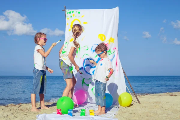 2 つの姉妹と弟の一日の時間でビーチで遊んで. — ストック写真