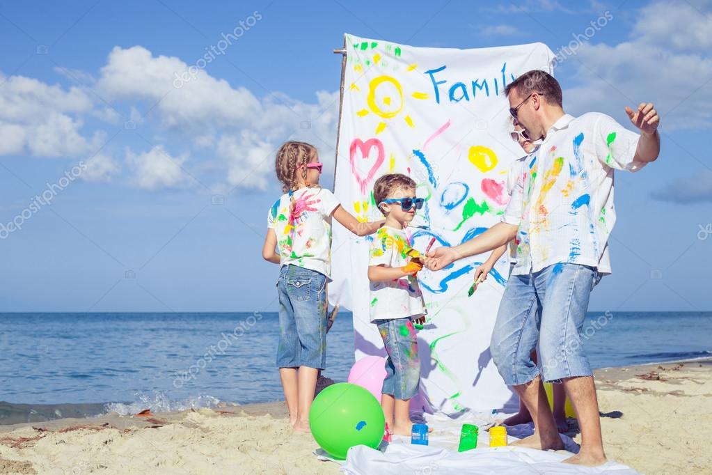 Father and children playing on the beach at the day time.
