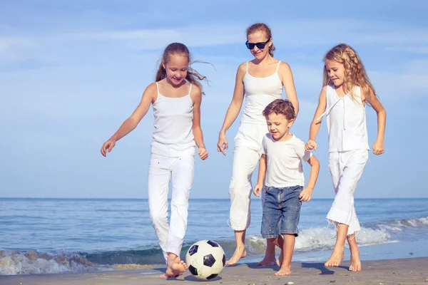 Madre e bambini che giocano sulla spiaggia durante il giorno . — Foto Stock