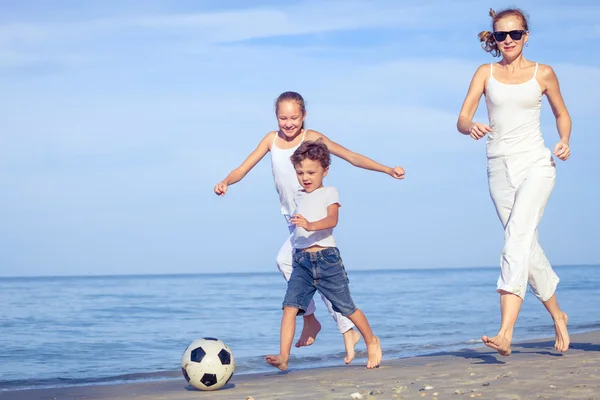 Mère et enfants jouant sur la plage le jour . — Photo