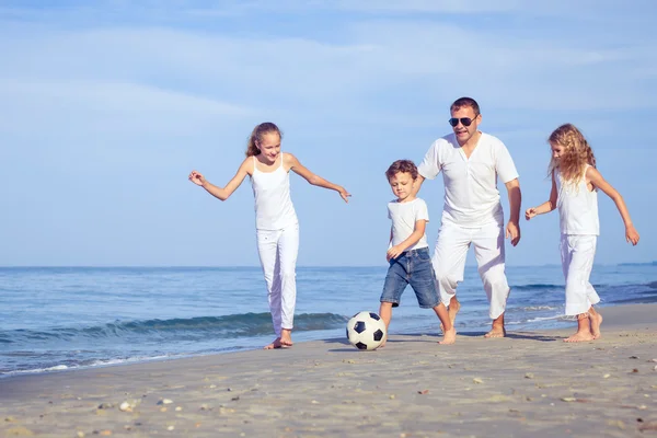 Vater und Kinder spielen tagsüber am Strand. — Stockfoto