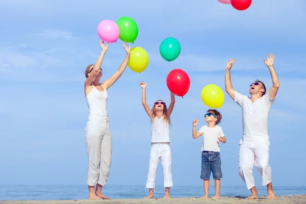 Happy family jumping on the beach at the sunset time. — Zdjęcie stockowe