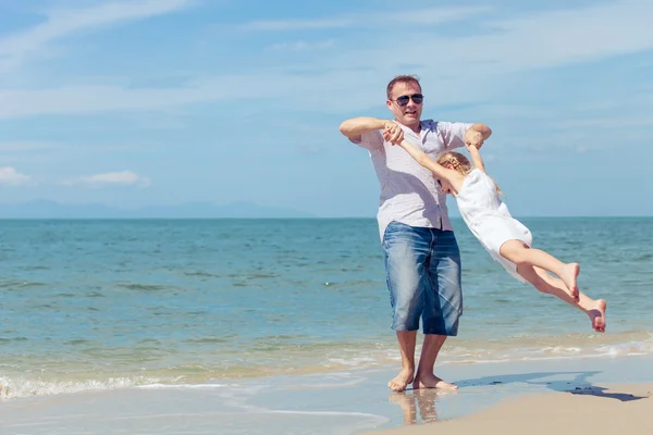 Ojciec i córka gra na plaży w czasie dnia. — Zdjęcie stockowe