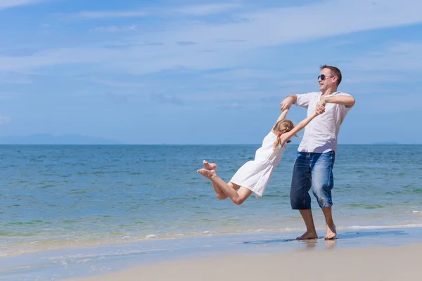 Padre e hija jugando en la playa durante el día . — Foto de Stock