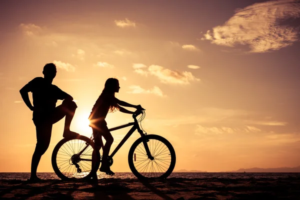 Vader en dochter spelen op het strand op de zonsondergang keer. — Stockfoto