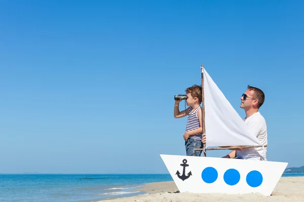 Vader en zoon spelen op het strand op het moment van de dag. — Stockfoto