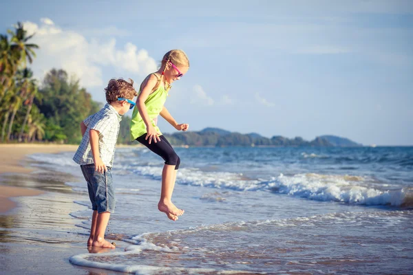 Glada barn som leker på stranden på dagarna. — Stockfoto