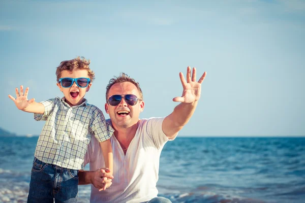 Pai e filho brincando na praia na hora do dia . — Fotografia de Stock