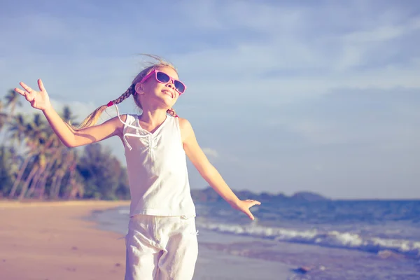 Mała dziewczynka tańczy na plaży w czasie dnia. — Zdjęcie stockowe