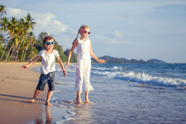Šťastné děti si hrají na pláži v denní době. — Stock fotografie