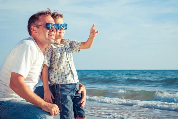 Pai e filho brincando na praia na hora do dia . — Fotografia de Stock