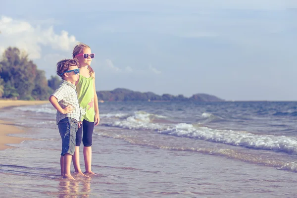 Glada barn som leker på stranden på dagarna. — Stockfoto