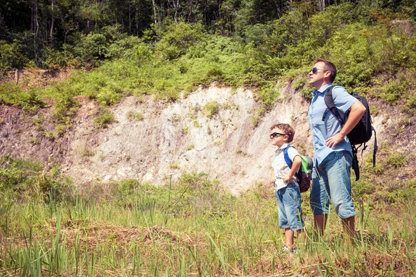 Padre e figlio in piedi vicino allo stagno durante il giorno . — Foto Stock