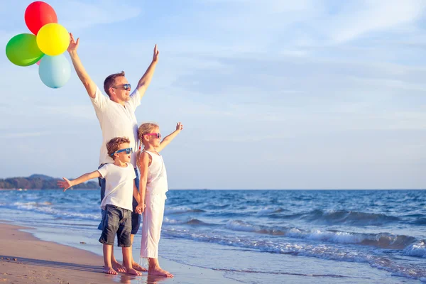 Vader en kinderen spelen op het strand op het moment van de dag. — Stockfoto