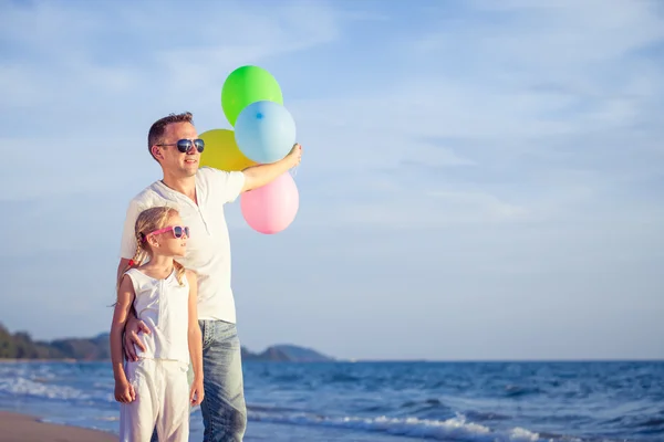 Vader en dochter spelen op het strand op het moment van de dag. — Stockfoto