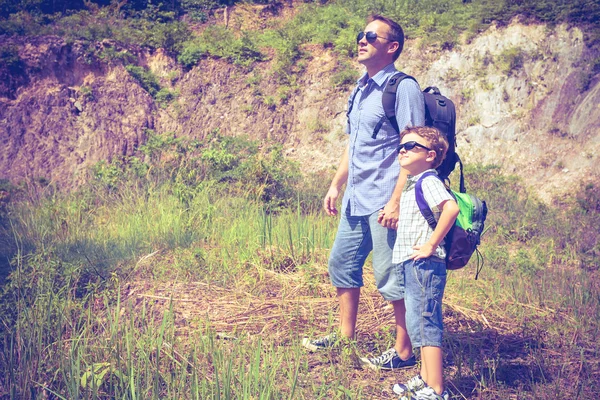 Padre e figlio in piedi vicino allo stagno durante il giorno . — Foto Stock
