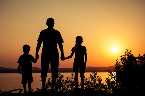 Father and children playing on the coast of lake — Stock Photo, Image
