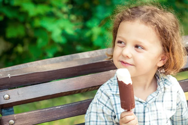 Mały chłopiec jedzący lody w parku — Zdjęcie stockowe