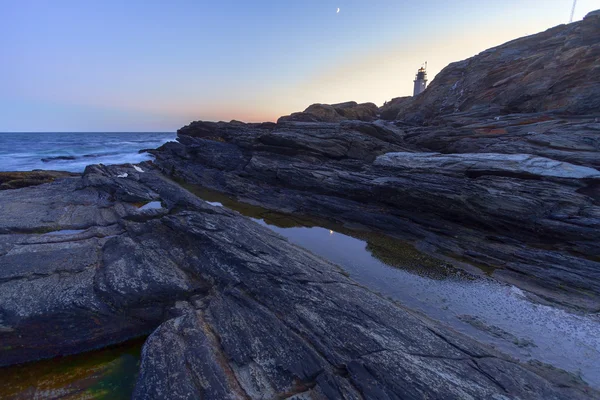 Puesta de sol en una costa rocosa . — Foto de Stock