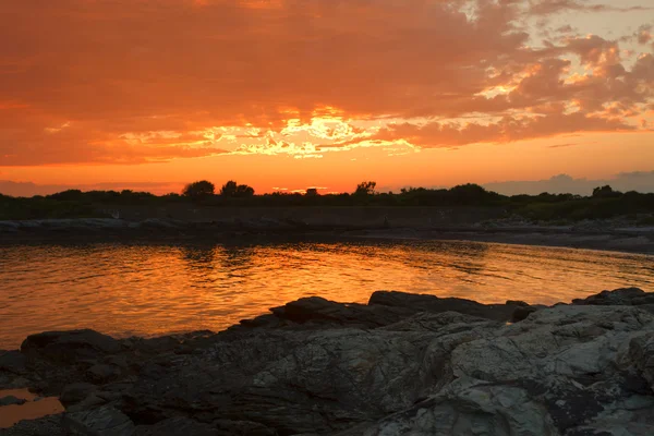 Puesta de sol en una costa rocosa . — Foto de Stock